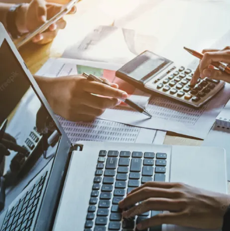 Image of laptop, calculator and documents on a table.